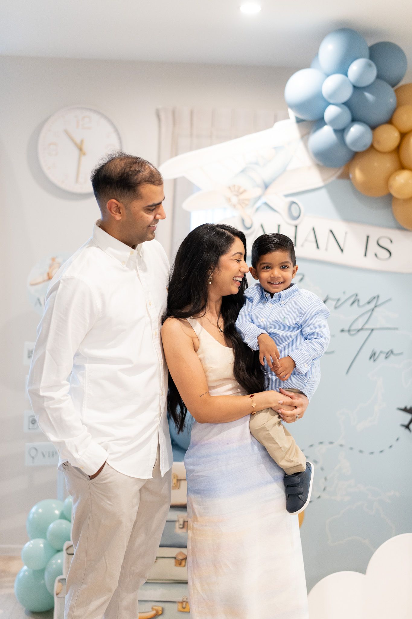 Candid family moment with Ahan smiling in his mother’s arms during his 2nd birthday party photography session