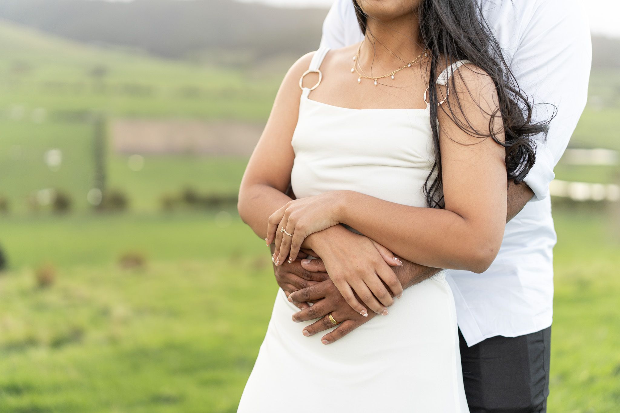 Close-up of Komal’s white dress and engagement ring as Amish holds her during a relaxed couples photoshoot