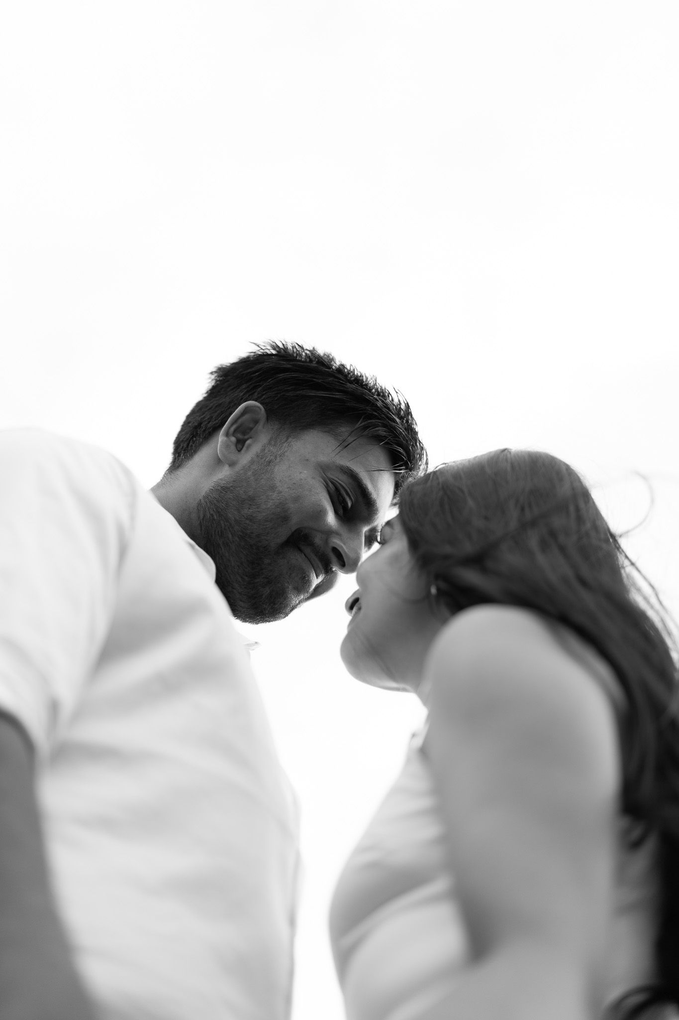 Black and white couples photography in Auckland with intimate low angle shot capturing romantic connection and soft expressions