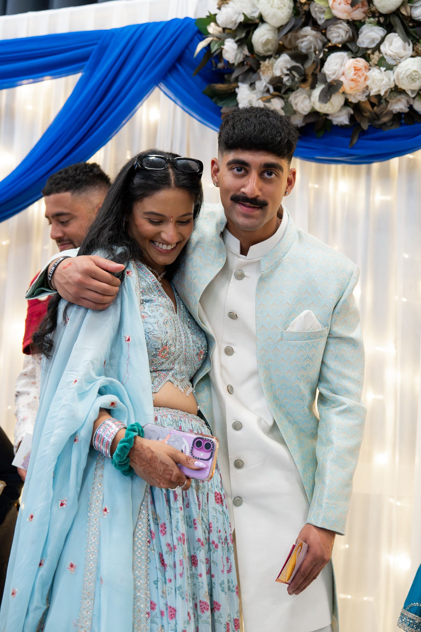 Cousins during Indian Mosaru ceremony in traditional attire under floral backdrop captured in wedding photography in Auckland