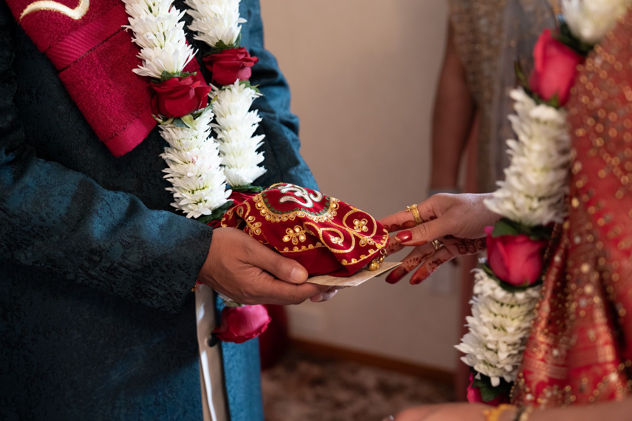 Indian wedding ritual exchanging ceremonial gifts with garlands and traditional attire during pre wedding Shantak photography in Auckland
