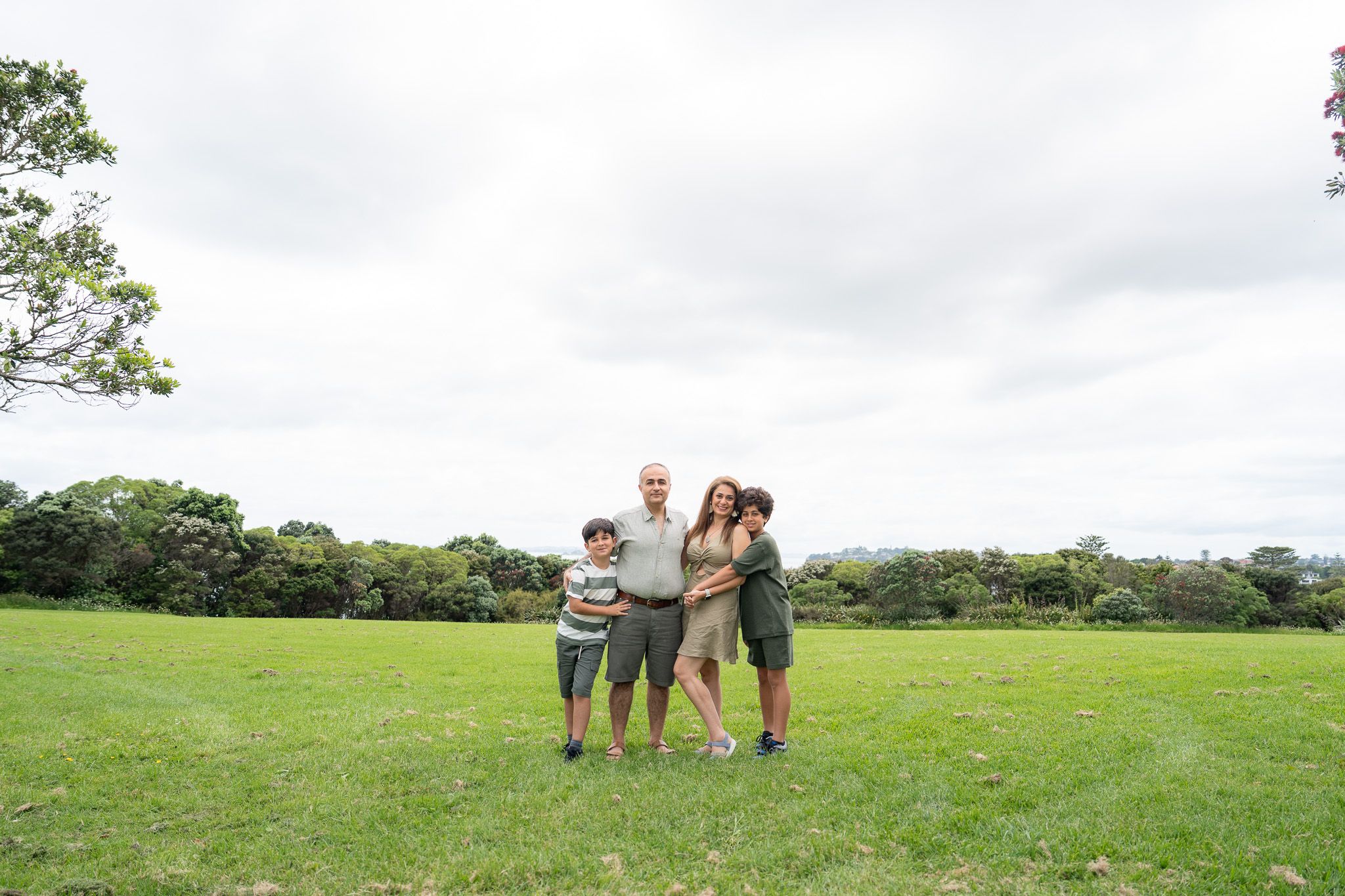 Family photography at Michael Joseph Savage Memorial in Auckland with Mona, Ali and their boys standing together on the open lawn