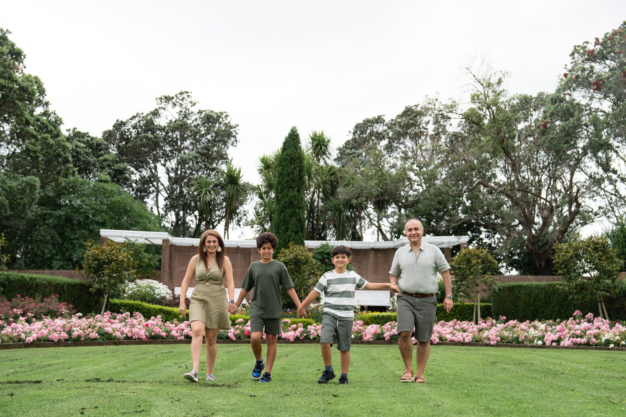 Fun family photography in Auckland with Mona, Ali and their boys walking hand in hand through the gardens at Michael Joseph Savage Memorial