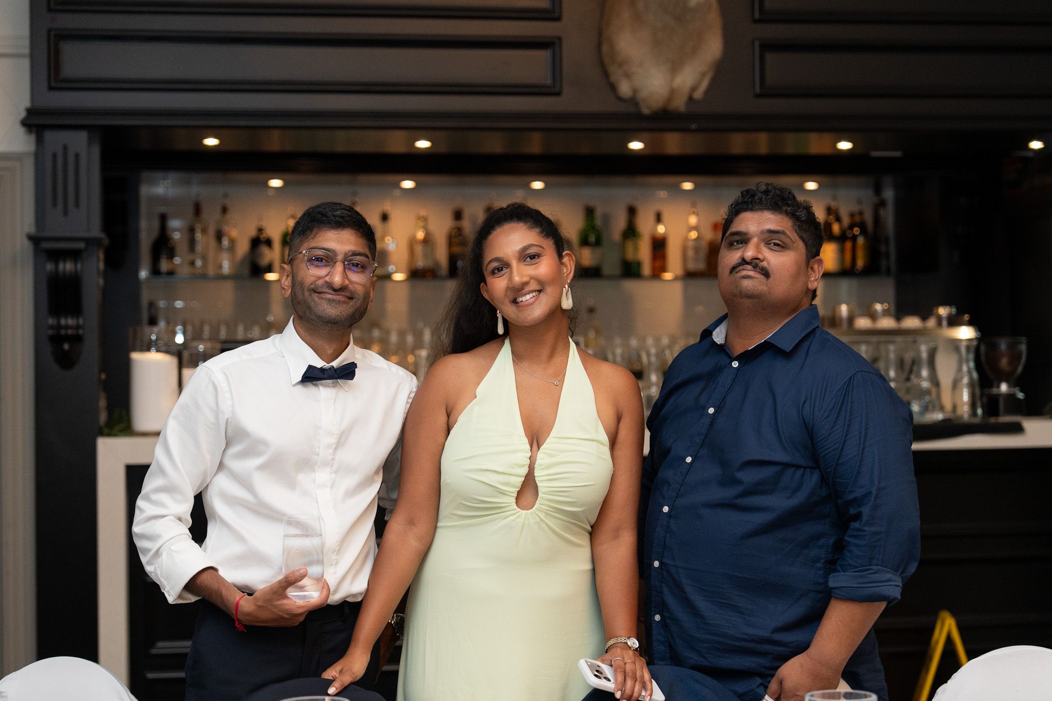 Guests posing for portrait in front of bar at Bracu Estate South Auckland Indian wedding reception photography