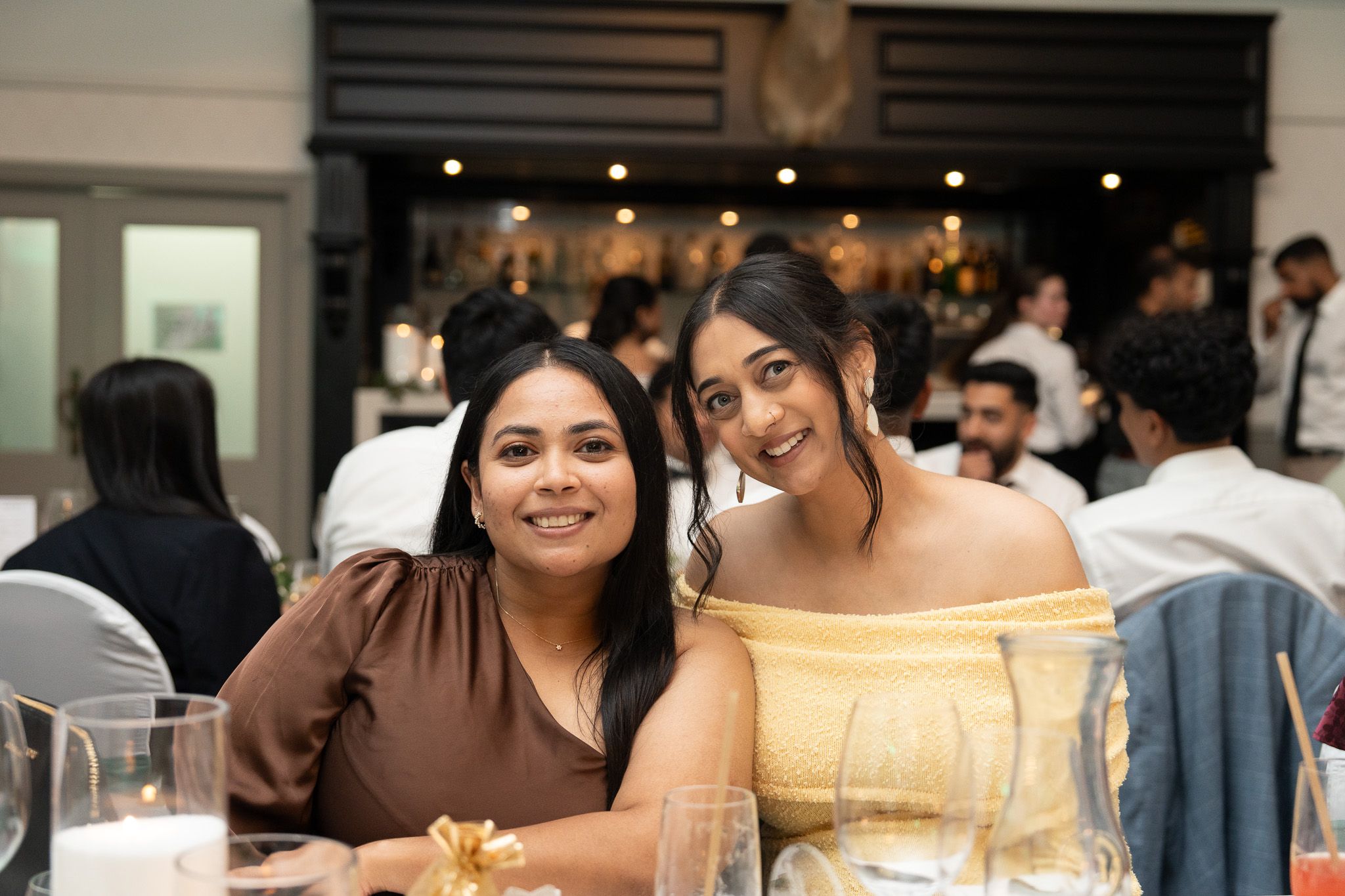 Guests smiling at table during Indian wedding reception at Bracu Estate South Auckland candid wedding photography capturing celebration atmosphere