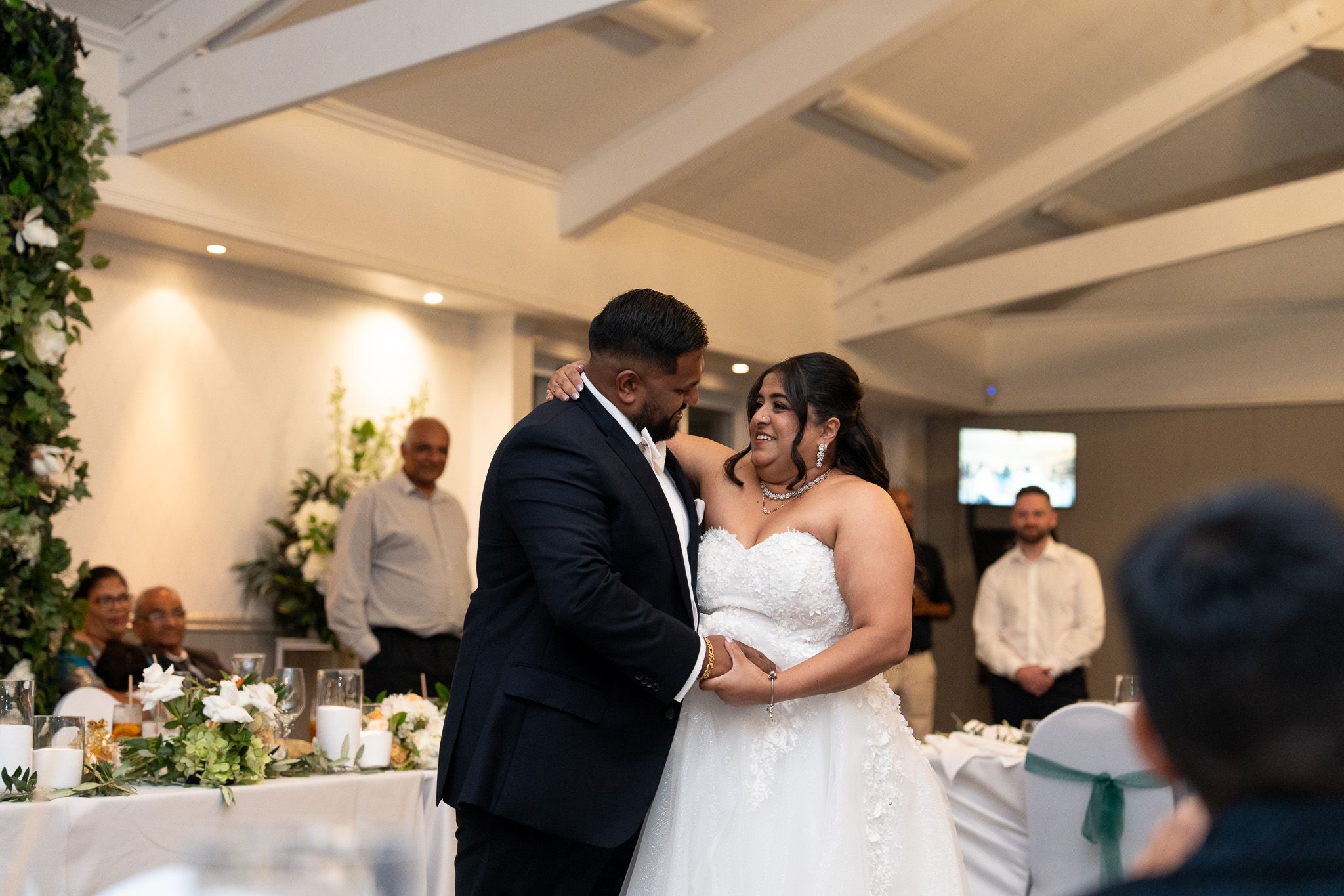 Bride and groom sharing first dance surrounded by guests at Bracu Estate South Auckland Indian wedding reception photography