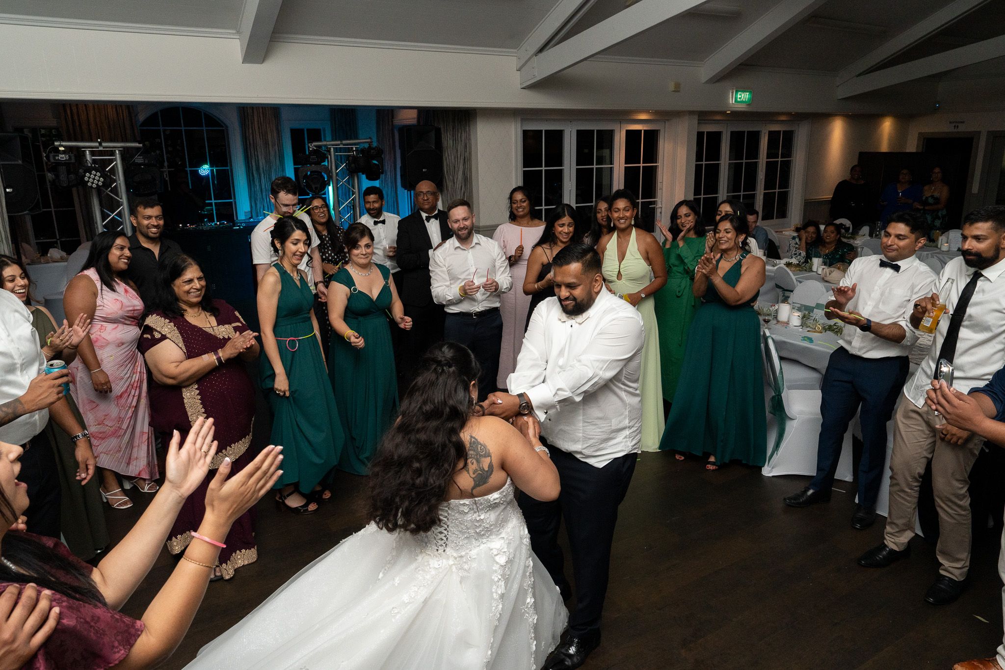Bride and groom dancing in circle of guests during reception at Bracu Estate South Auckland Indian wedding photography