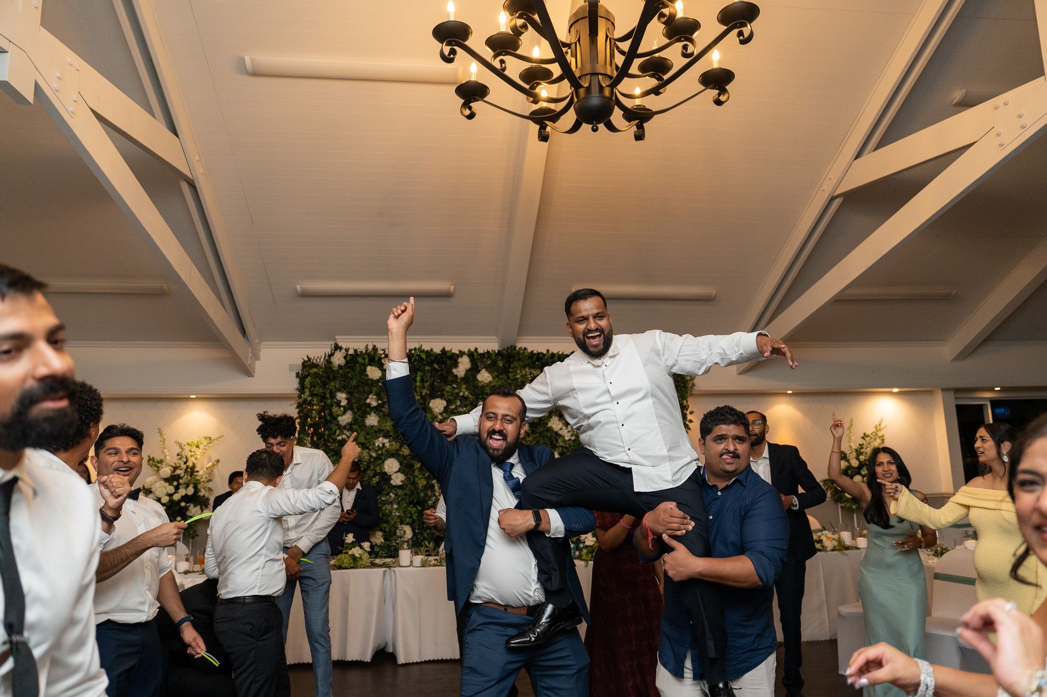 Groom lifted on shoulders during lively reception celebration at Bracu Estate South Auckland Indian wedding photography