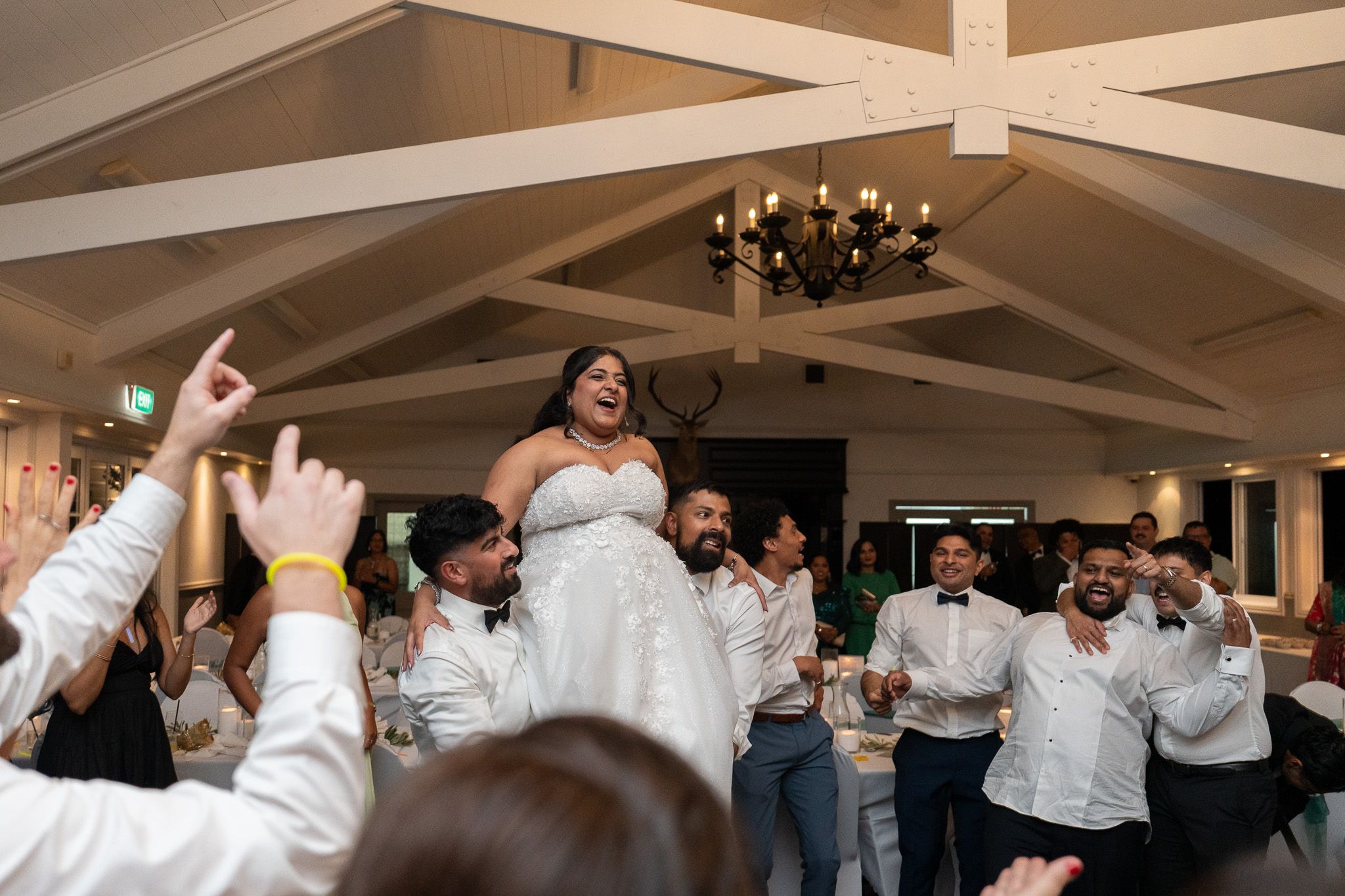 Bride lifted by friends during energetic dance floor celebration at Bracu Estate South Auckland wedding photography